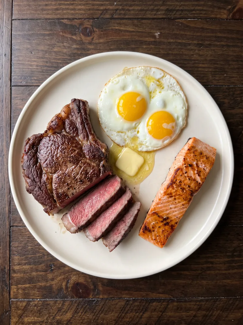 A carnivore plate of steak, eggs, butter and salmon